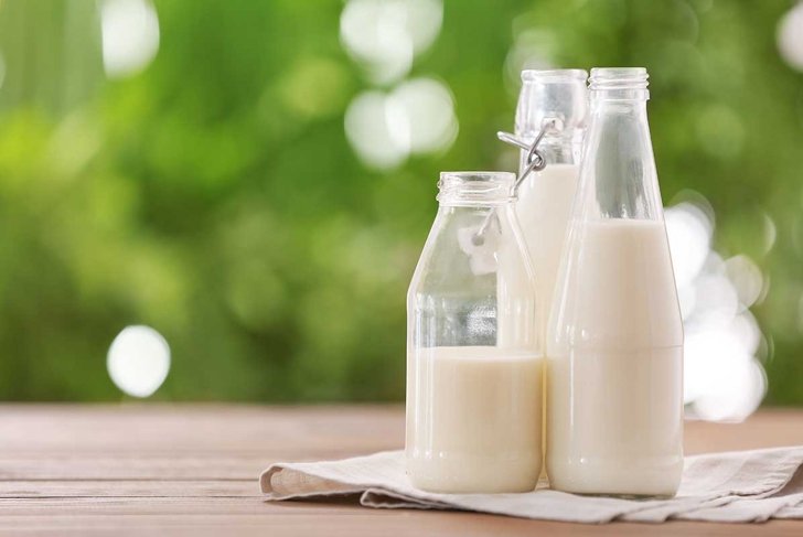 Bottles of fresh milk on table outdoors