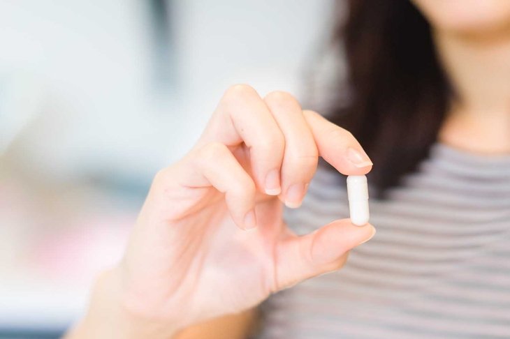 Close Up Of Girl holding Pill showing medicine.Natural Essential oil.Nutritional Supplements.Sport,Diet Concept.Capsules Vitamin And Dietary Supplements.