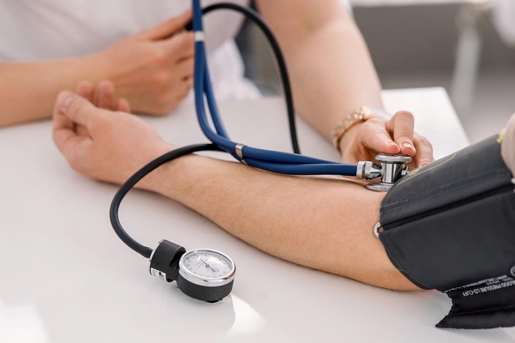 The doctor uses a sphygmomanometer with a stethoscope to check the patient\'s blood pressure in the hospital.